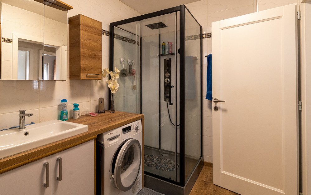Modernes Badezimmer mit begehbarer Duschkabine und praktischer Wäscheintegration, photo 27 of 32